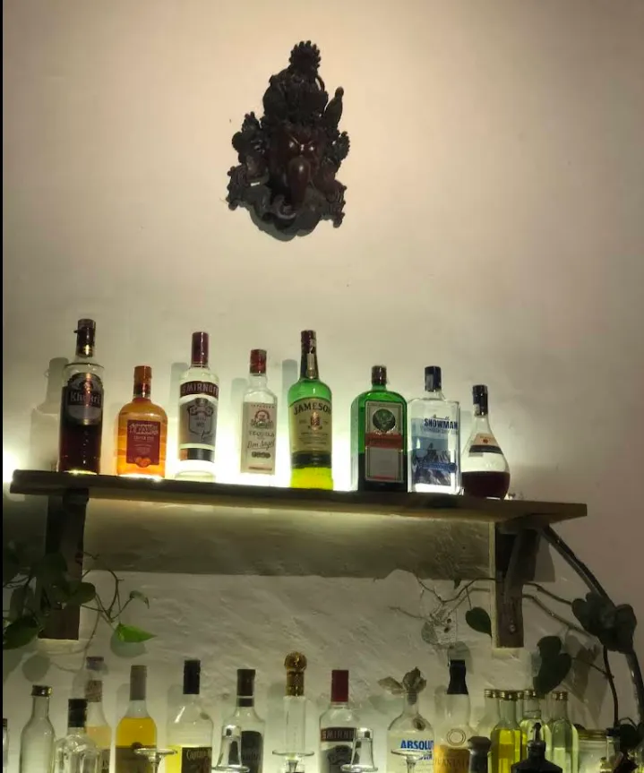 The shelf of Himalayan herbal products and spirits beneath a carved deity at the Sherpa bar.