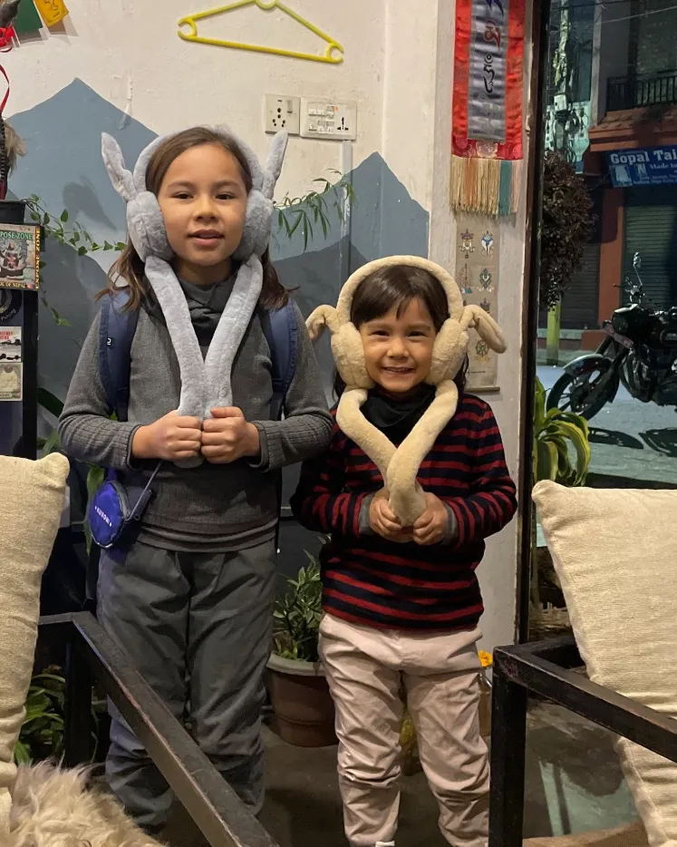Young guests wearing welcome khata scarves at the entrance.